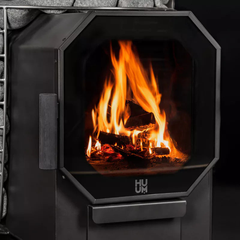 HUUM HIVE Flow Holzsaunaofen mit loderndem Feuer in der Brennkammer.