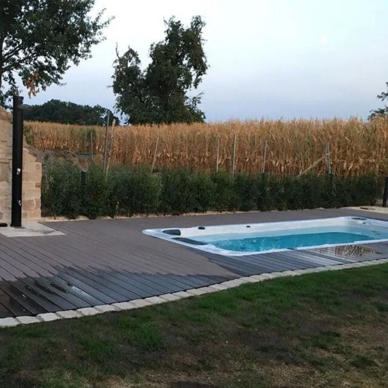 Passion Spas Aquatic 2 – moderner Swim Spa mit Lounge-Bereich und Natursteinwand für Garten oder Terrasse