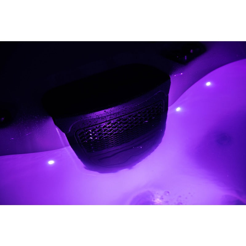 Platinum Spas Tahiti Hot Tub – Nahaufnahme des integrierten Lautsprechers bei violetter LED-Beleuchtung, sorgt für stilvolle Klangerlebnisse im nächtlichen Spa-Betrieb