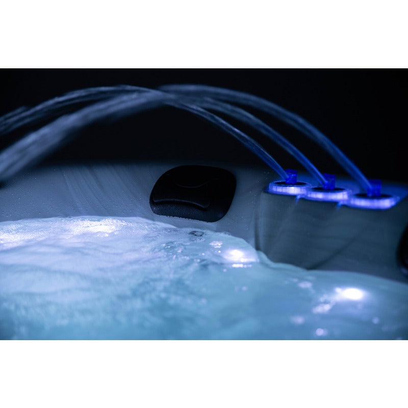 Platinum Spas Tahiti Hot Tub – stimmungsvolle Nachtaufnahme mit beleuchteten Wasserfontänen und weichem LED-Licht, ideal für entspannte Spa-Abende im Freien