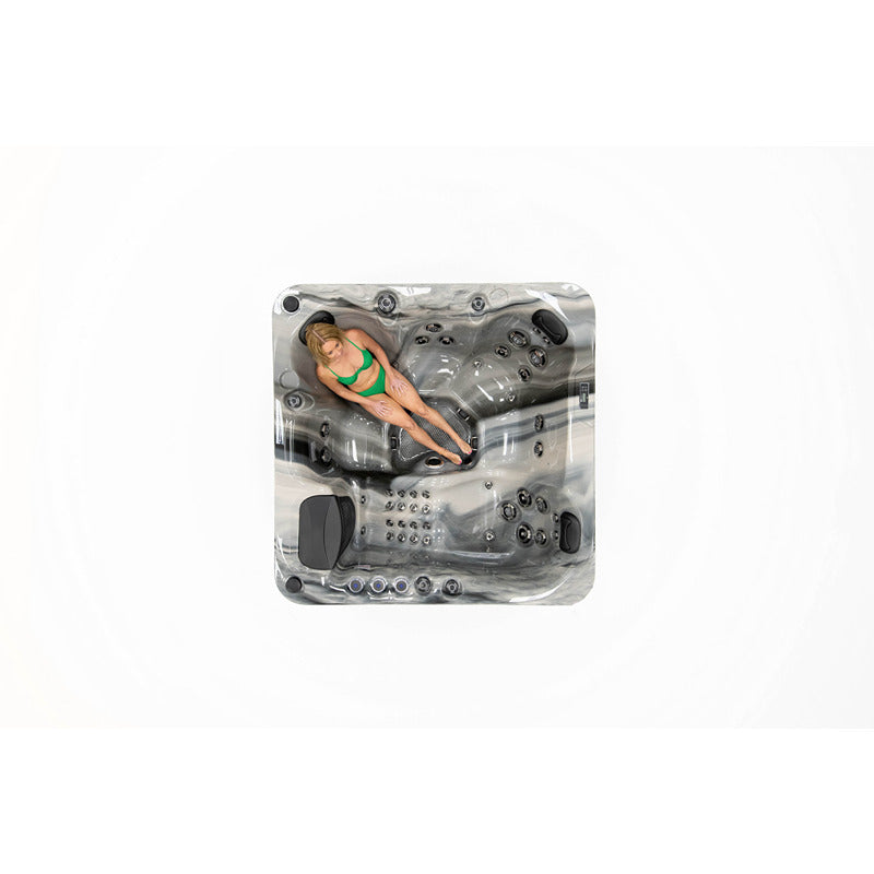 Platinum Spas Refresh Outdoor Whirlpool – Draufsicht mit Frau im grünen Bikini, liegend auf der ergonomischen Liegefläche, Farbe: Odyssey.
