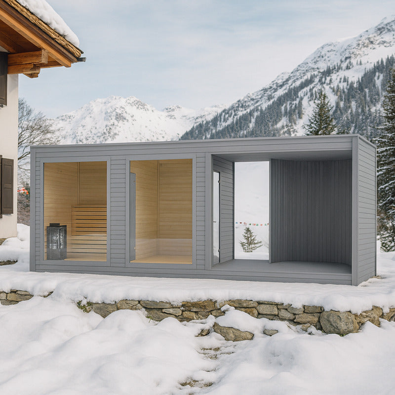 Moderne Gartensauna Tauras Balance in grauem Holzdesign neben einer Chalet-Villa im verschneiten Skigebiet, umgeben von Alpenpanorama und winterlicher Naturkulisse – stilvolle Outdoor-Wellness im Schnee.