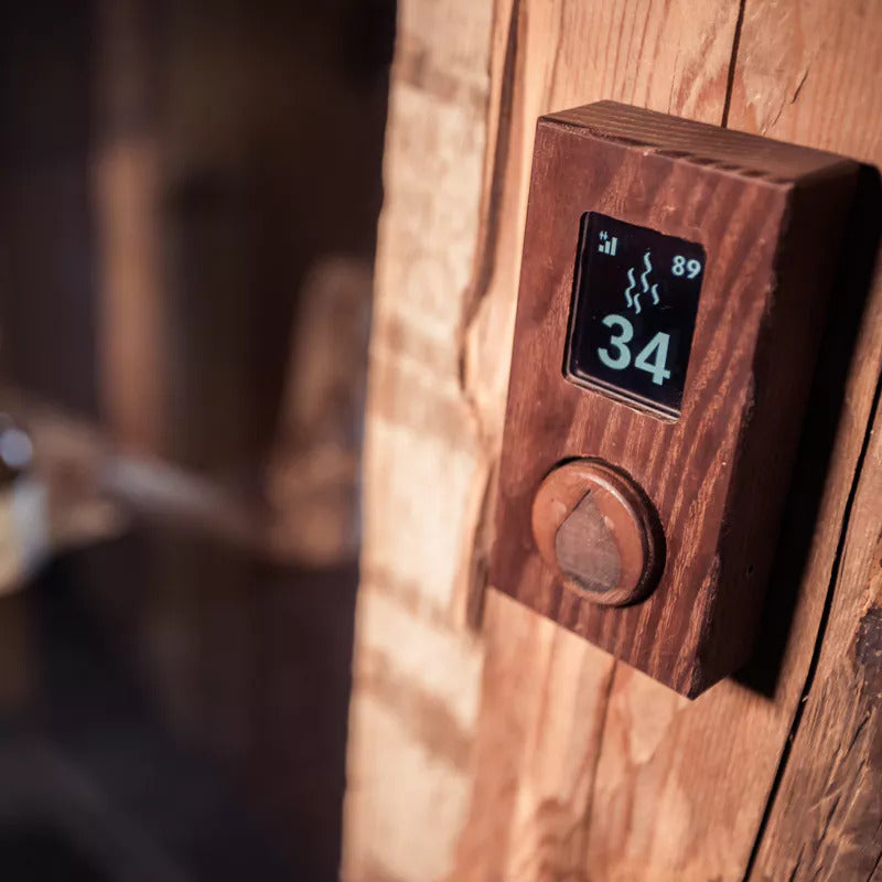 HUUM UKU WOOD Gehäuse – montiert an rustikaler Sauna, Display mit Temperaturanzeige