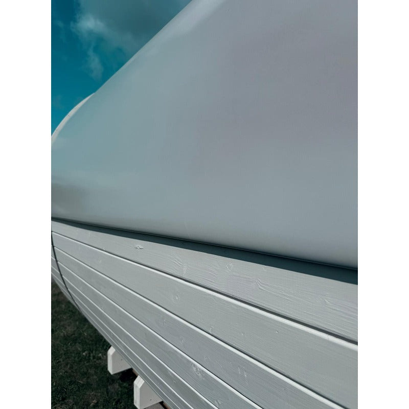 Detailaufnahme der glatten Dachplane und der weißen Holzverkleidung einer Celsium Joris Large Fasssauna