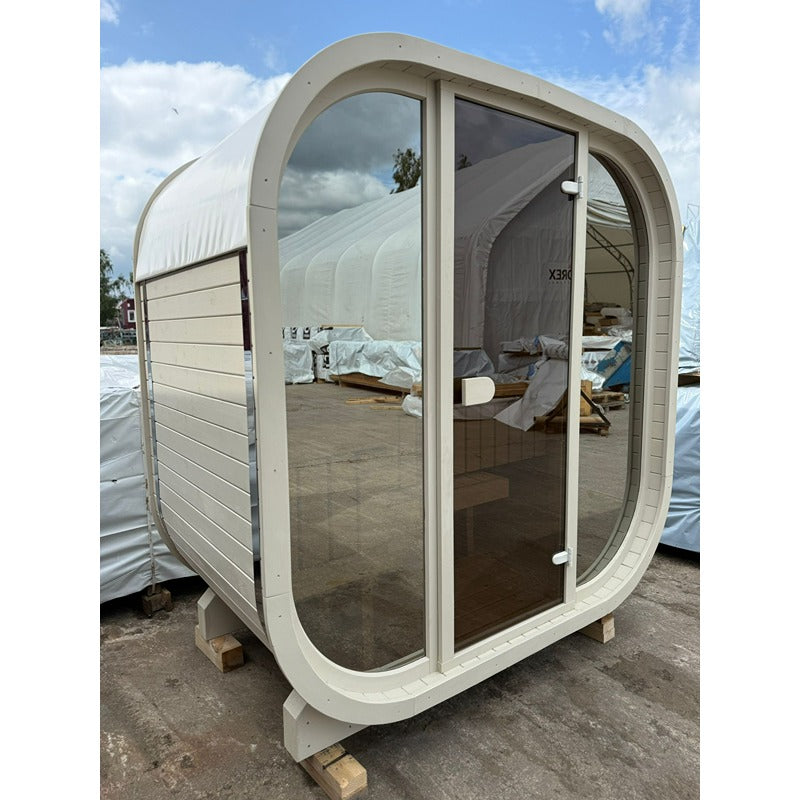 Celsium Ula Mini Sauna in Beige mit Ganzglasfront während der Montage – kompakte Designsauna für zwei Personen mit heller Holzoptik und sanft gerundeter Form