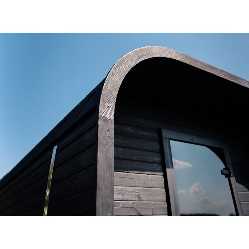 Detailaufnahme der Celsium Ula Small Sauna in Shou Sugi Ban Schwarz – gebranntes Holz mit elegant geschwungener Rahmenarchitektur und Glasfront