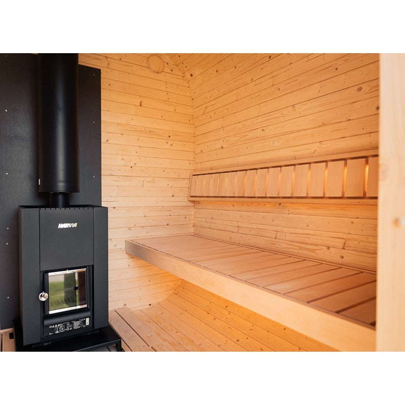 Innenansicht der Celsium Ula Small Sauna mit HARVIA Holzofen, zweistufiger Sitzbank und indirekter Beleuchtung – hochwertige Verarbeitung für stilvolles Saunieren