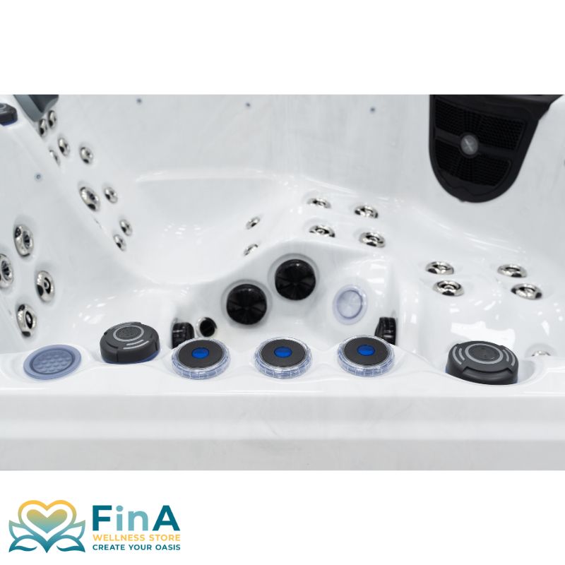 Innenansicht des FinA Xaluna Outdoor Whirlpools mit Fokus auf Steuerungselemente, beleuchtete Drehregler und zahlreiche Massagedüsen an Sitz- und Liegeflächen.