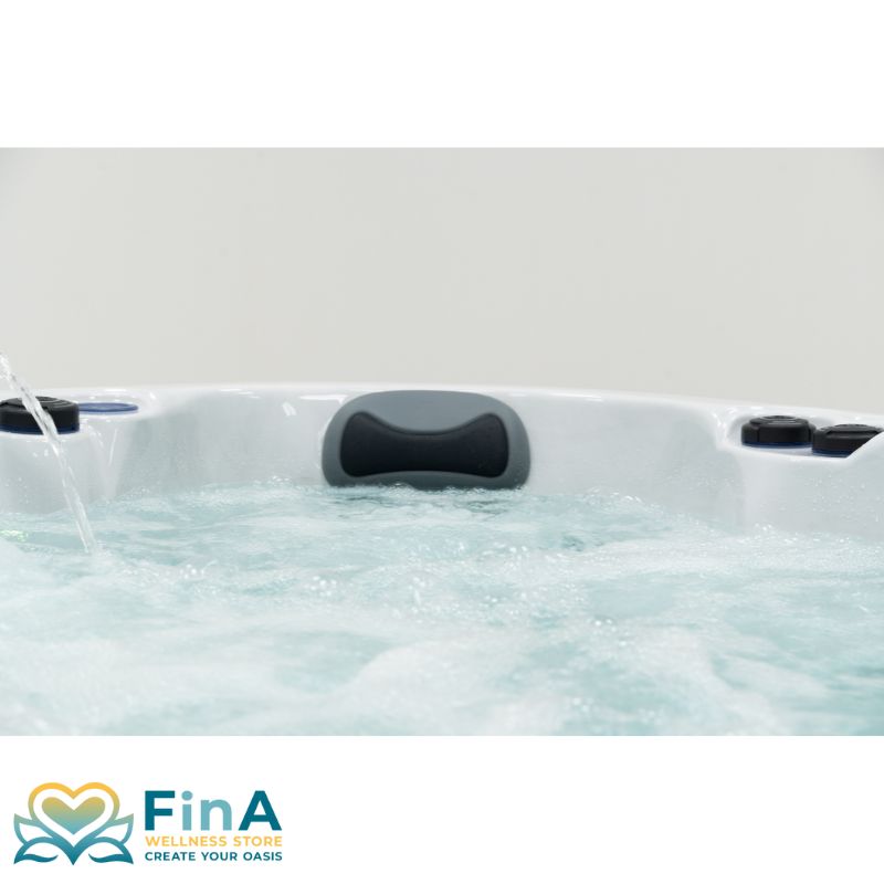 Detailansicht einer ergonomischen Kopfstütze am FinA Xaluna Outdoor Whirlpool, eingebettet in die weiße Acrylwanne mit sprudelndem Wasser im Vordergrund