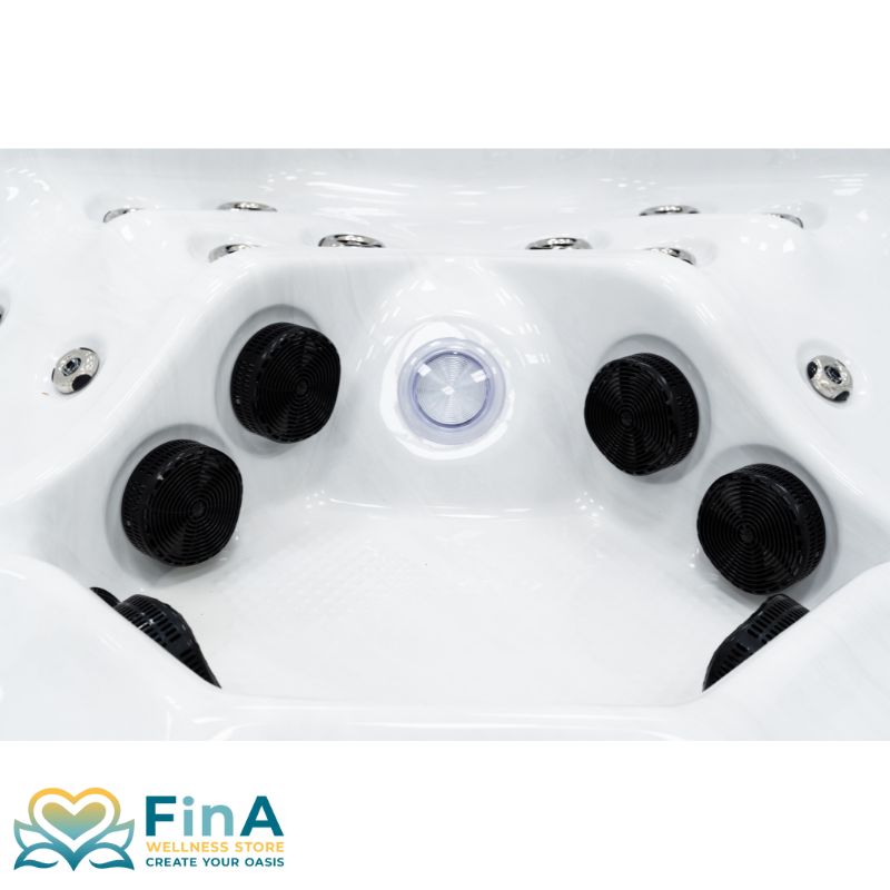 Detailansicht der Sitzmulde im FinA Xaluna Whirlpool mit mehreren schwarzen Massagedüsen und zentraler LED-Leuchte in weißer Acrylwanne.