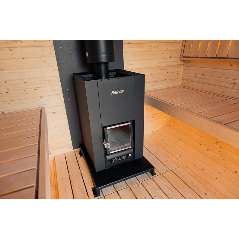 Innenraum einer Holzsauna mit zentral platziertem Harvia Saunaofen und zwei gegenüberliegenden Sitzbänken aus hellem Holz