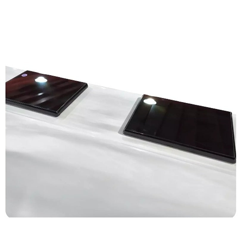 Zwei geschlossene Touchpad-Abdeckungen auf dem Rand des Platinum Spas Helios Pro Swim Spa in moderner Glasoptik