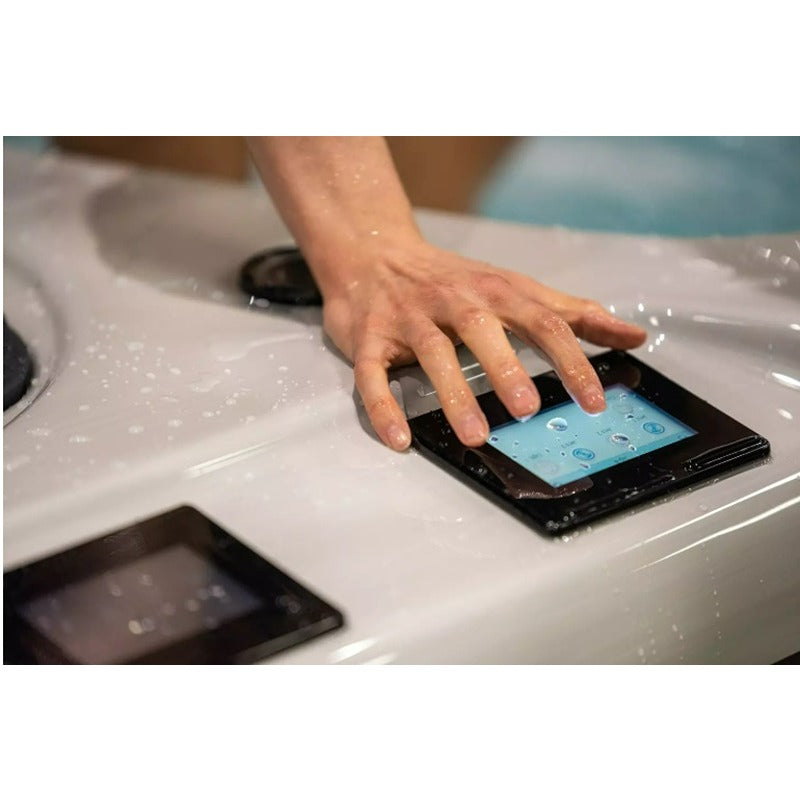 Hand bedient das Balboa Touch Display am Platinum Spas Helios Pro Swim Spa zur Steuerung von Funktionen und Einstellungen