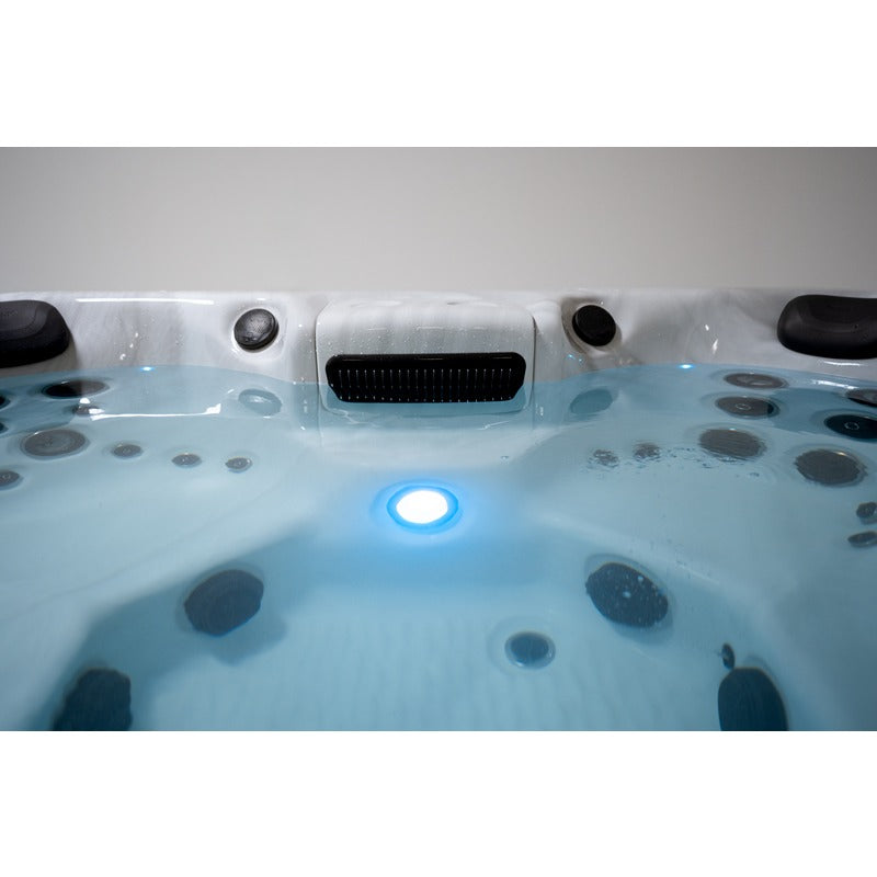 Beleuchteter Innenraum des Platinum Spas Oslo Hot Tubs mit gefülltem Wasserstand – zentrales LED-Licht und Massagedüsen schaffen stimmungsvolle Atmosphäre bei Nacht.