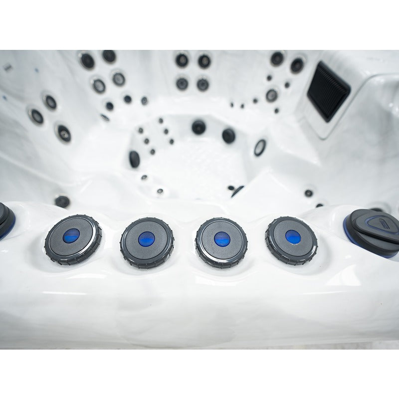 Detailaufnahme der fünf blauen Steuerdrehregler am Rand des Platinum Spas Oslo Hot Tubs – im Hintergrund kraftvolle Jet-Anordnung und strukturierter Bodenbereich.