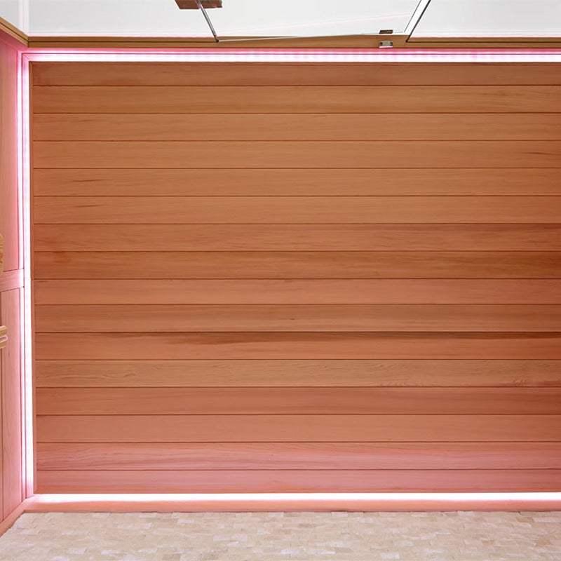 Holzsauna mit horizontalen Zedernbrettern und leuchtend rosa Neonrahmen in moderner Architektur-Szenerie