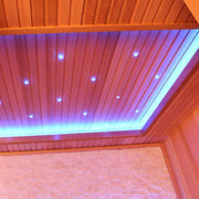 Infrarotsauna mit roter Zedernholzverkleidung, farbiger LED-Deckenbeleuchtung in Blau und Pink sowie eingebauten Wärmeelementen