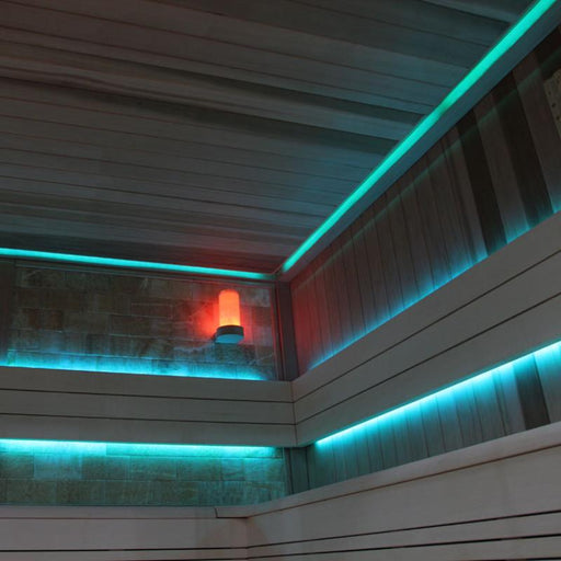 Moderne Innensauna mit türkisen LED-Deckenleuchten und rotem Saunaöfen-Element an der Wand, helles Holzinterieur