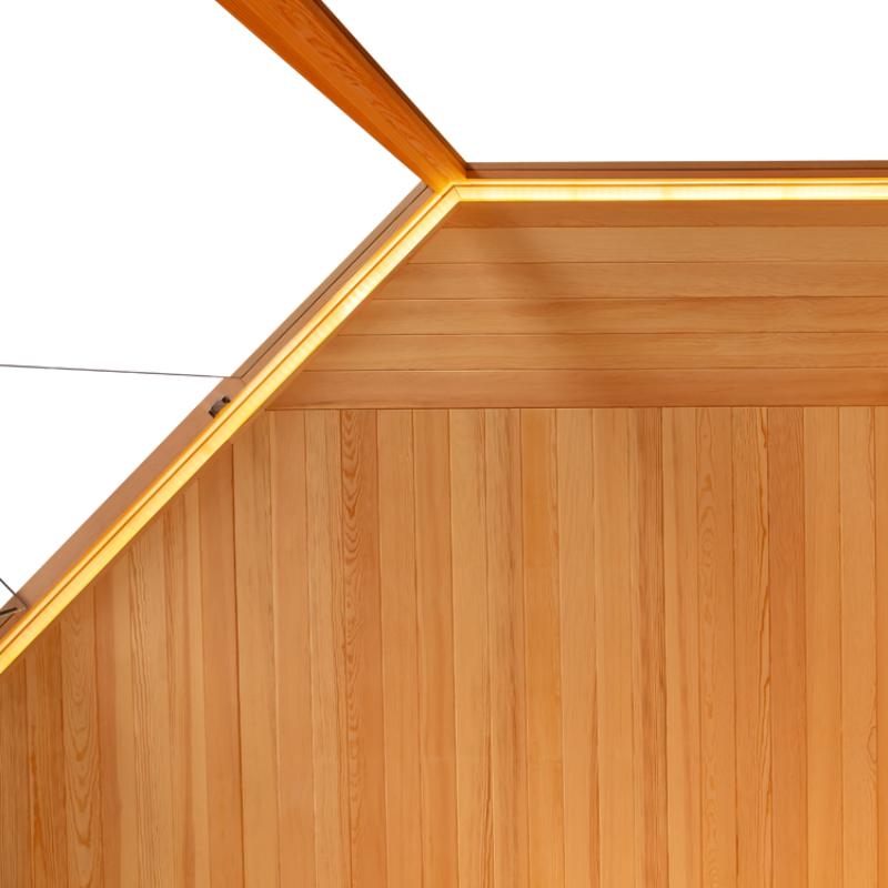 Detailansicht der Eckkonstruktion einer Holzsauna mit vertikalen Kiefernholzbrettern und goldenem Aluminiumprofil an der Kante