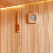 Saunainnenwand aus hellem Pinienholz mit analogem Thermometer und Flüssigkeitsthermometer in Holzrahmen