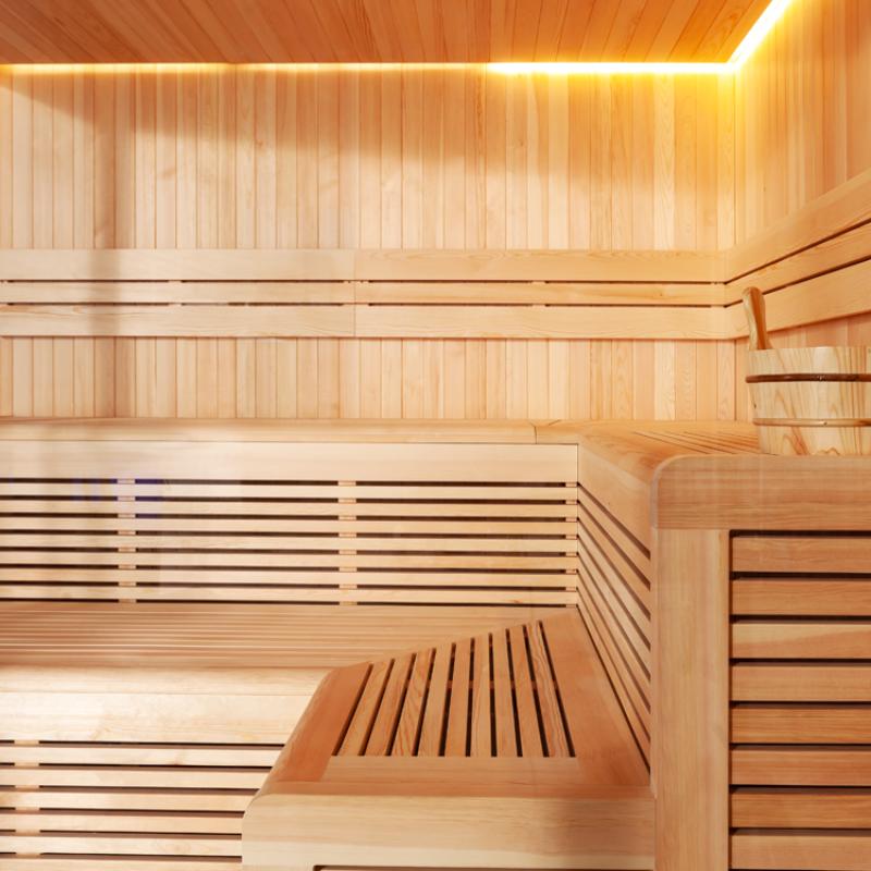 Innenansicht der EAGO AWT E1806XL Sauna mit hellem Pinienholz, mehrstufigen Bänken und indirekt beleuchteter Holzdecke