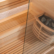 Innenansicht der EAGO AWT E1813C Sauna mit Pinienholz-Bänken, Glasfront und Saunaofen mit Steinen