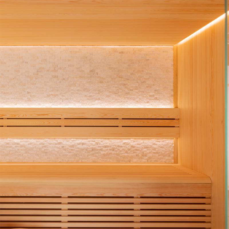 Innenansicht einer EAGO AWT E1813C Sauna mit Pinienholz-Verkleidung, oben beleuchtete Rückenlehne und unten Sitzbänke.