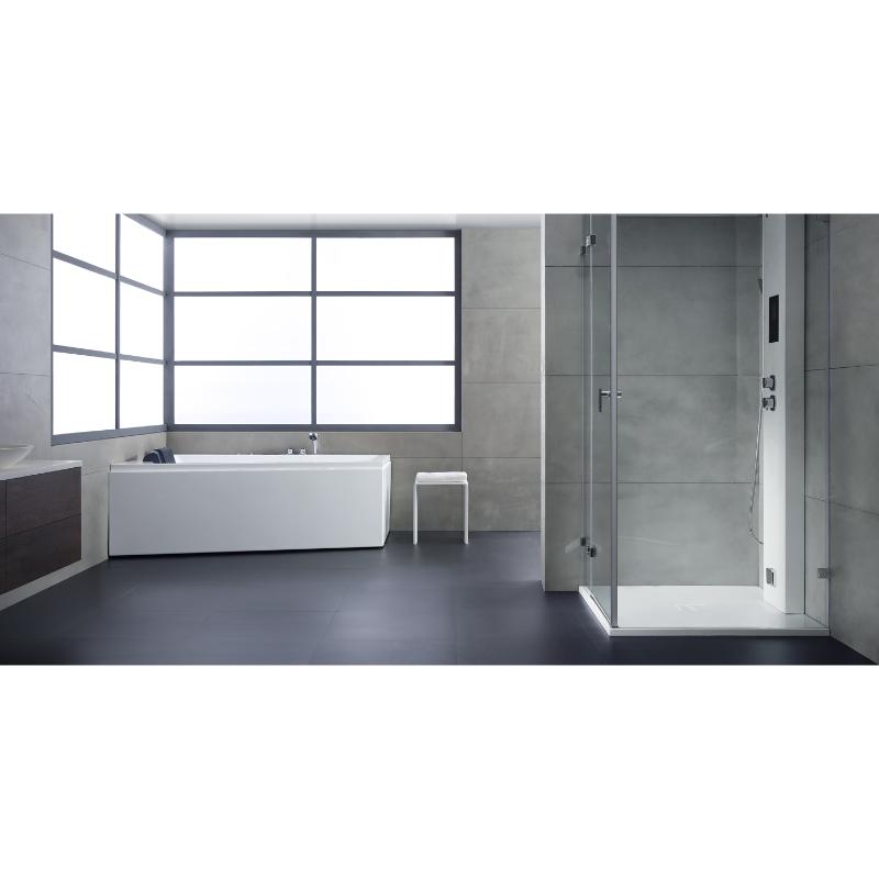 Modernes Badezimmer mit weißer Eckbadewanne EAGO AWT GE105E und bodenebener Dusche mit Glastüren, Betonoptik-Wänden und großem Fenster.