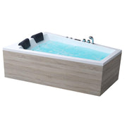 EAGO AWT GE105E Whirlpool mit hellblauem Wasser, weißer Innenseite, zwei schwarzen Kopfkissen und Holzoptik-Verkleidung in Grauton, seitlich installierte Bedienelemente und Armaturen sichtbar
