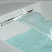 Wasserstrahl aus verchromtem Auslauf in weiße Whirlpool-Wanne mit türkisblauem Wasser