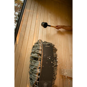 Detailaufnahme Saunaofen in der Celsium Jonas Small Sauna – Aufgussmoment auf Harvia Ofen, Wasserdampf und Holzverkleidung sichtbar.