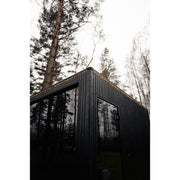 Detailansicht der Ecke der Celsium Jonas Grand Gartensauna mit Glasfront und LED-Dachlinie.
