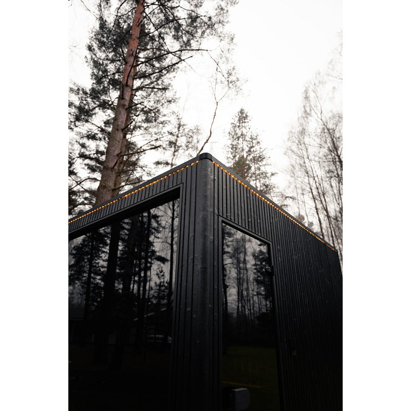 Detailansicht der Ecke der Celsium Jonas Grand Gartensauna mit Glasfront und LED-Dachlinie.
