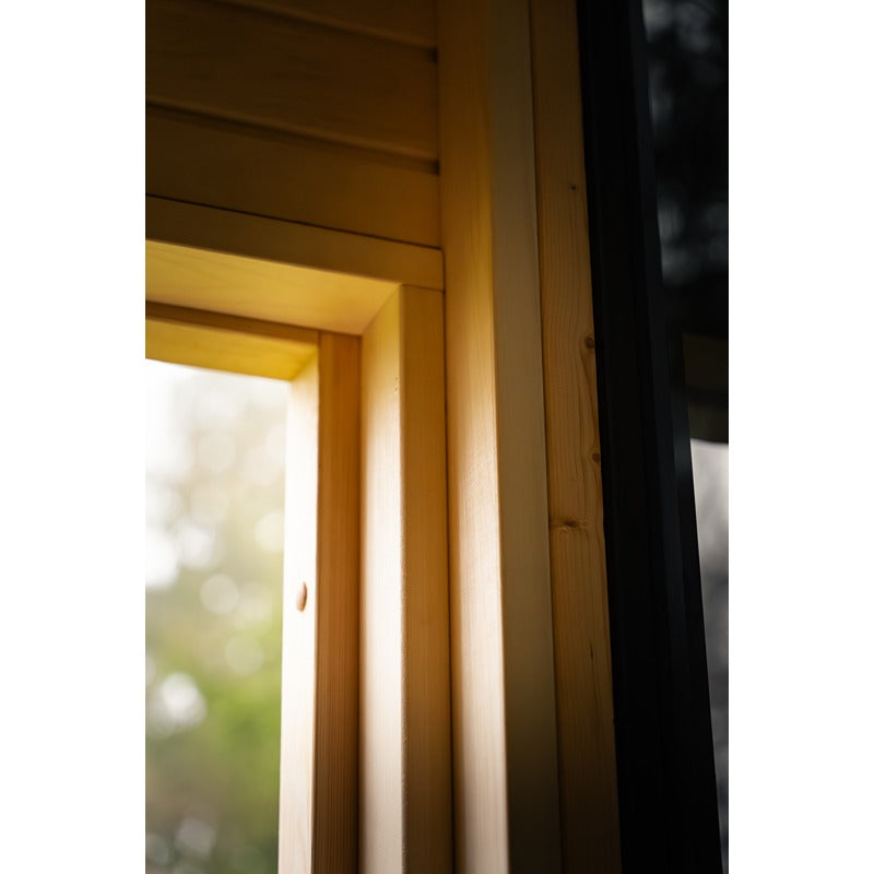 Detailaufnahme des Türrahmens aus Holz an der Glastür der Gartensauna.