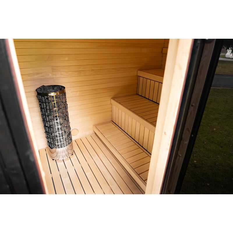 Innenraum der Celsium Jonas Grand Gartensauna mit Harvia Saunaofen und Holzbänken.
