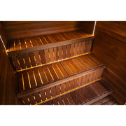 Zweistufige Saunabänke aus Holz mit warmer, indirekter Beleuchtung.
