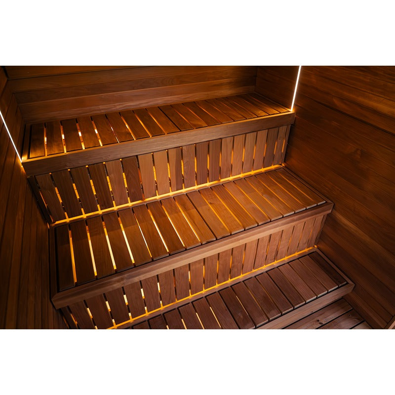 Zweistufige Saunabänke aus Holz mit warmer, indirekter Beleuchtung.
