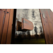 Holzgriff an der Glastür der Celsium Jonas Grand Gartensauna.
