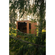 Celsium Jonas Grand Gartensauna mit Glasfront, eingebettet in eine natürliche Waldumgebung.
