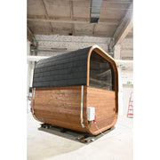 Hekla Cube Sauna mit Holzverkleidung und schwarzen Dachschindeln in Werkstatt, moderne zylindrische Form mit großem Fenster