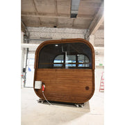 Hekla Cube Sauna mit gerundeter Form, Holzverkleidung und großer getönter Glasfront in einer Montagehalle