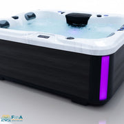 Seitliche Ansicht des FinA Aqualora Outdoor Whirlpools mit eingeschalteter violetter LED-Lichtleiste – modernes Farbspiel trifft elegantes Design.