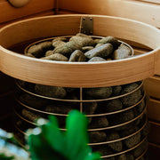  HUUM Saunaofen HIVE mit montierter Schutzreling – runde Holzumfassung mit Edelstahlklemmen