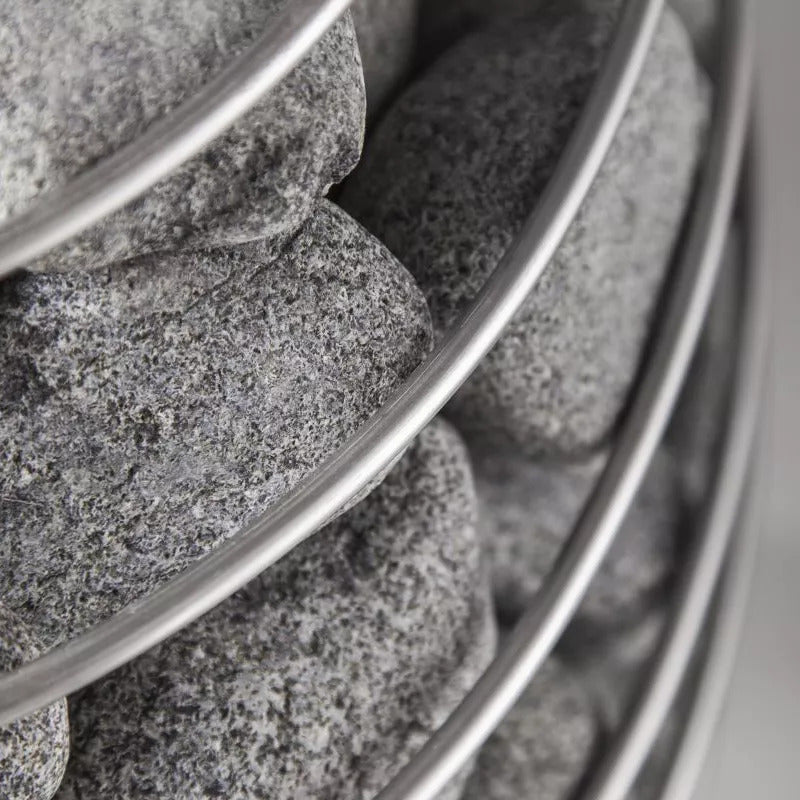  Detailansicht: HUUM Saunaofen mit dicht geschichteten, runden Saunasteinen aus Olivin-Diabas