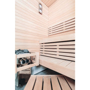 Harvia Vega Compact Elektro-Saunaofen mit Steinen in moderner Sauna mit hellen Holzwänden und schwarzen Liegen