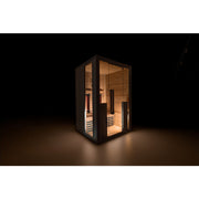 Beleuchtete Infrarotkabine im dunklen Raum – edle Materialkombination aus Holz und Glas
