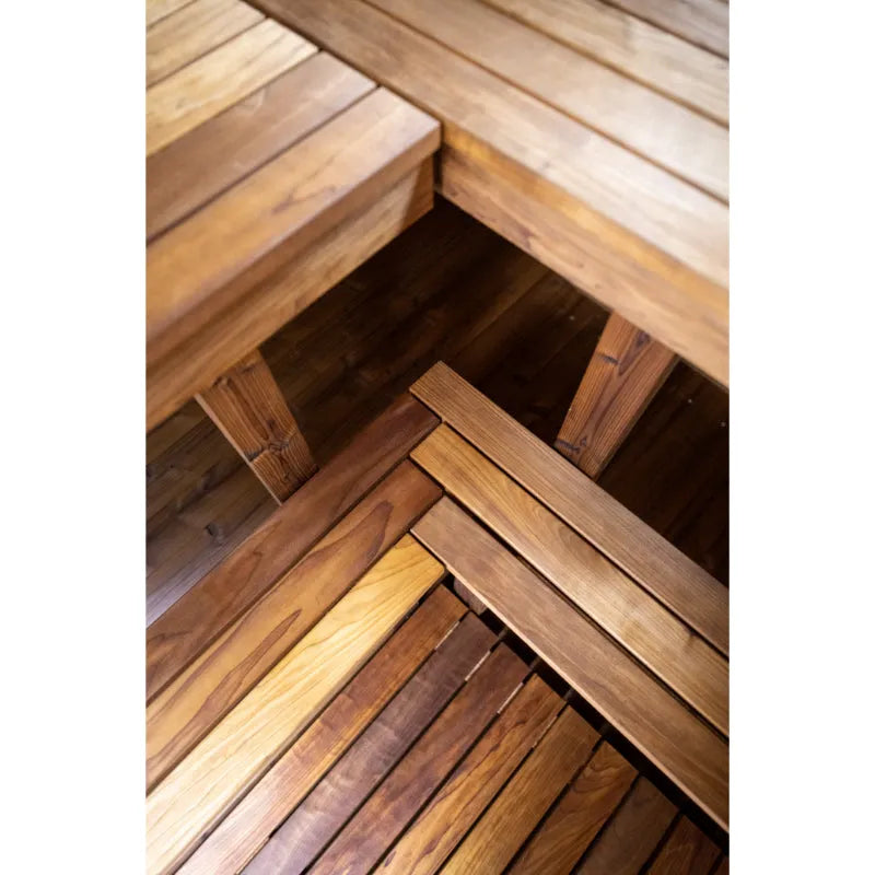 Detailaufnahme der Holzbänke in einer Hekla Cube Sauna mit gestapelten Sitzbrettern in verschiedenen Holztönen und Eckkonstruktion