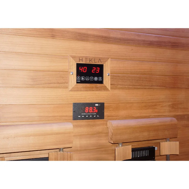 HEKLA Infrarotsauna mit digitaler Steuerung an Holzwand, Temperaturanzeige 40°C und rote LED-Anzeige 88.3, Kontrollpanel mit Funktionstasten