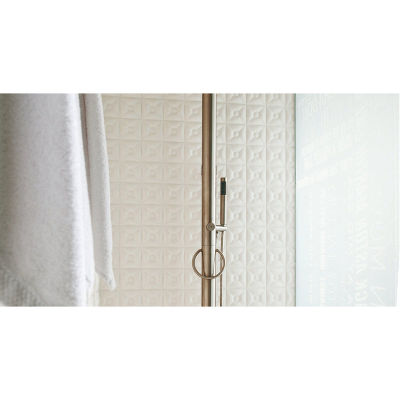 Edle Duscharmatur JEE-O Original mit Handbrause und Regenduschkopf an minimalistischer cremefarbener Kachelfliesen-Wand neben weißem Handtuch.