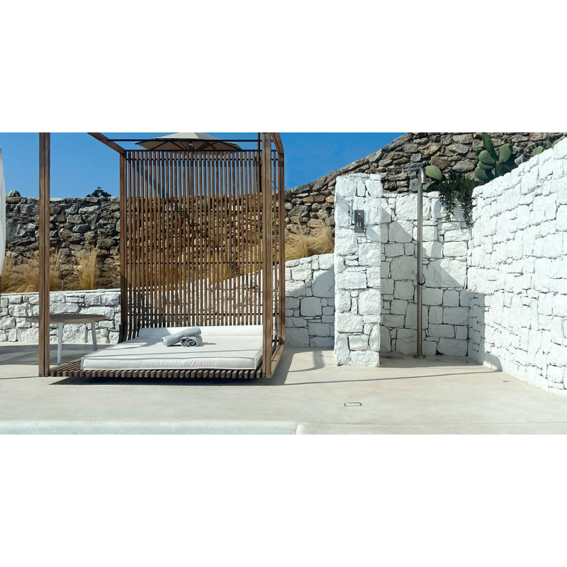 JEE-O Original Dusche 01 mit Holzrahmen und vertikalen Lamellen in minimalistische Außenanlage mit weißen Steinmauern und bergiger Landschaft